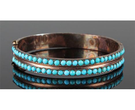 Yellow metal and turquoise set bangle with two rows of turquoise stones to the bangle, 5.6cm wide