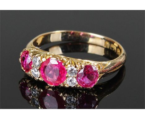 18 carat gold ruby and diamond set ring, with three rubies at approximately a total weight of 2.18 carats, with four diamonds