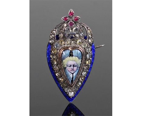 Unusual enamelled brooch. The central figural enamel centre with paste border, blue enamel edge, white metal read, 37mm high 