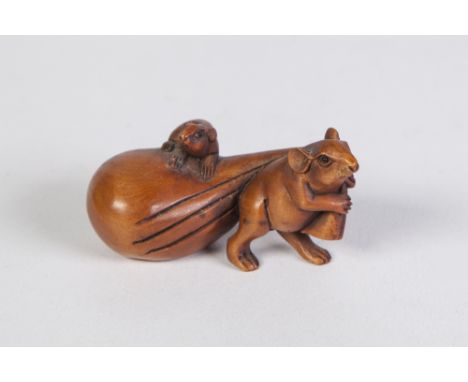 A JAPANESE WELL CARVED BOXWOOD NETSUKE of a mouse pulling a bag upon which is a smaller mouse, with glass inset eyes, signed 