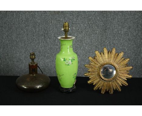 A suburst giltwood mirror, a Chinese porcelain table lamp (converted) with a lime green glaze, and another table lamp with a 