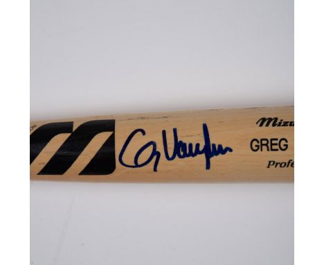 This is a natural wood-colored Mizuno Greg Vaughn model bat signed by Vaughn in blue ink. Dimensions: 34"L x 8"Cir. Manufactu