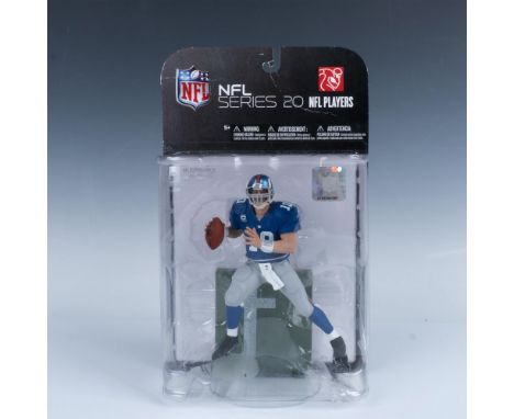 Unopened Eli Manning figurine in motion holding the football pre-throw. He is wearing the blue and grey Giants uniform #10. T