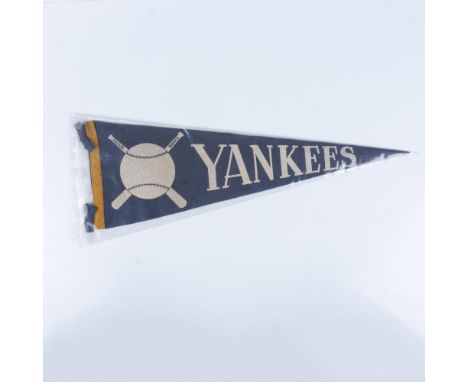 This piece of memorabilia is made of felt, colored blue and yellow, featuring the Yankees' name along with a depiction of a b