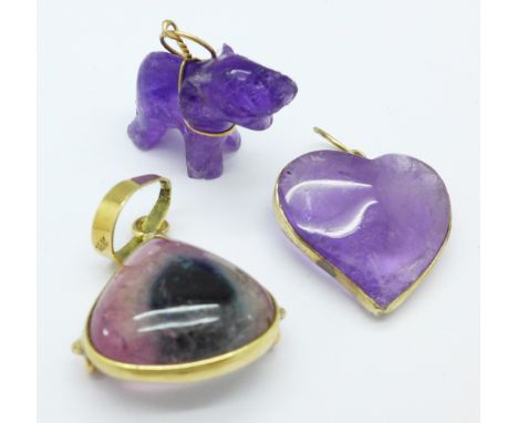 An 18ct gold mounted pendant and two yellow metal mounted amethyst charms