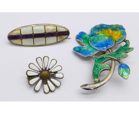 A silver and enamel brooch and two other enamel brooches