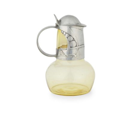  ARCHIBALD KNOX FOR LIBERTY & CO. CLARET JUG AND COVER, 1904 pewter, glass by James Powell & Sons. Whitefriars, stamped regis