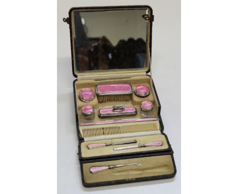 An embossed cased silver and pink enamel dressing table set , some damages, one item missing, Birmingham 1926