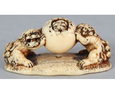A GOOD JAPANESE EDO/MEIJI PERIOD IVORY NETSUKE, carved in the form of two shi-shi supporting a sphere or egg from out of whic
