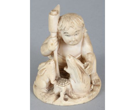 A SIGNED JAPANESE MEIJI PERIOD IVORY OKIMONO OF A BOY WITH TWO RABBITS, the boy kneeling and holding an axe, the base with an