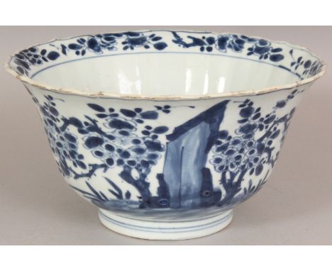 A CHINESE KANGXI PERIOD BLUE & WHITE FLUTED PORCELAIN BOWL, the sides painted with a garden scene of plum blossom and rockwor