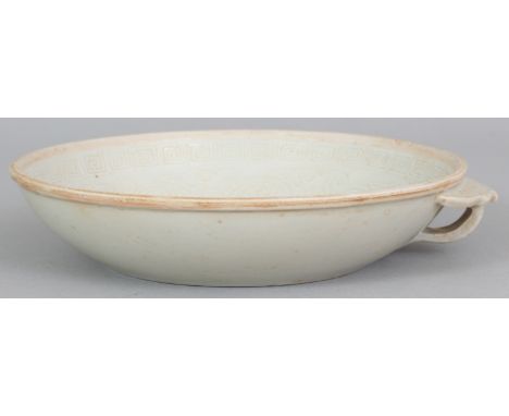 A CHINESE SONG STYLE PORCELAIN BOWL, with an unglazed rim and an unusual scroll and ruyi form handle, the interior moulded be