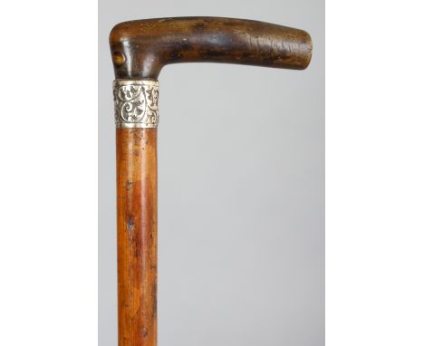 ANOTHER RHINOCEROS HORN HANDLED WOOD WALKING STICK, with a hallmarked and embossed silver collar, the rhino horn of brownish-