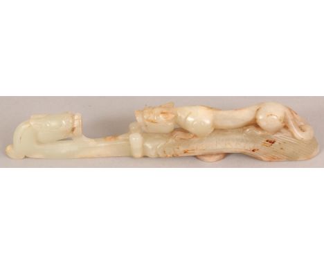 A CHINESE CELADON JADE BELT HOOK, of longer than average size, the stem carved with a chilong confronting the dragon-head hoo