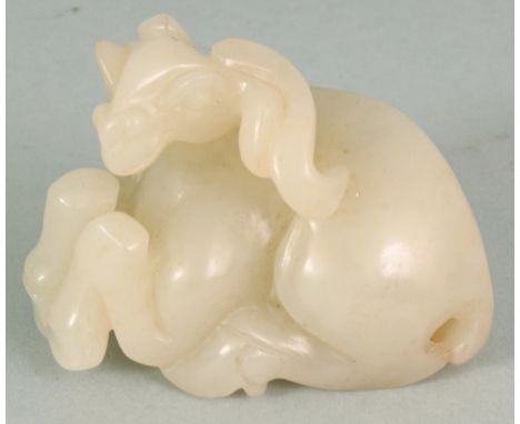 A CHINESE JADE MODEL OF A SEATED RAM, the stone of pale celadon tone, 2.3in long & 1.75in high.