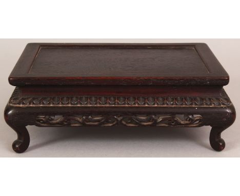 A 19TH/20TH CENTURY CHINESE RECTANGULAR CARVED HARDWOOD STAND, with pierced foliate frieze and scroll feet, 8.5in x 6.5in x 2