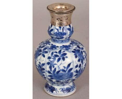 A SMALL CHINESE KANGXI PERIOD SILVER MOUNTED BLUE & WHITE PORCELAIN VASE, the sides painted with floral panels, the base with