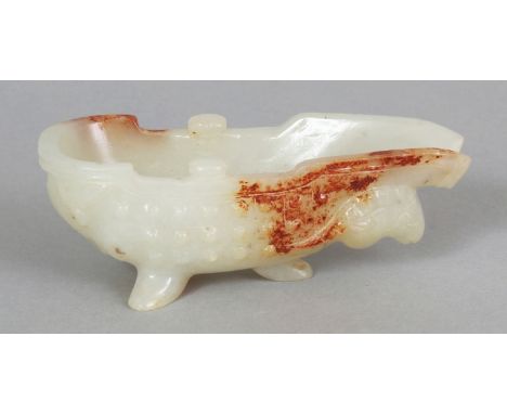 A CHINESE WHITE JADE-LIKE POURING VESSEL OF ARCHAIC FORM, the stone with russet inclusions, 3.25in long.