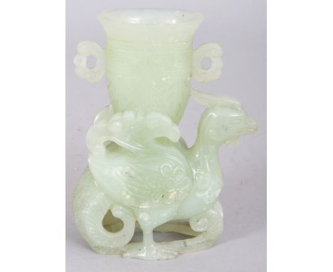 AN EARLY 20TH CENTURY CHINESE CELADON JADE CARVING OF A PHOENIX, supporting an archaic vase, 4in high.