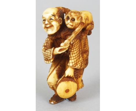 A GOOD QUALITY JAPANESE MEIJI PERIOD STAINED IVORY NETSUKE OF A MONKEY PERFORMER, unsigned, the walking man holding a drum in