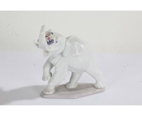 Lladro elephant, with a raised trunk and flowers, 13cm high