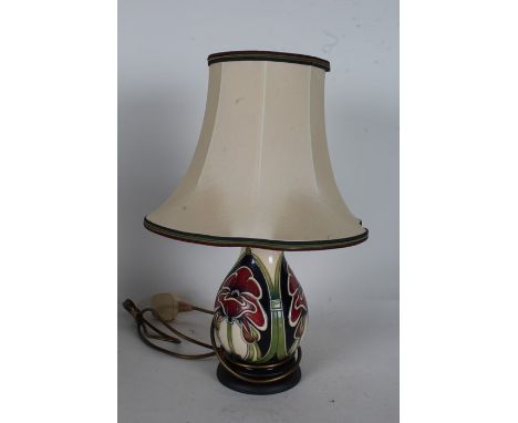 Moorcroft pottery table lamp, with stylised poppy design, raised on circular base, 22cm high excluding fitting and shade