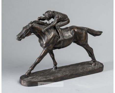 A bronze resin sculpture of a racehorse and jockey,depicting a realistic model of jockey on horseback raised upon a plinth ba