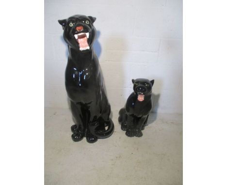 Two ceramic fireside black Panthers. Left fang on large panther is chipped. Heights are 84cm and 48cm. 