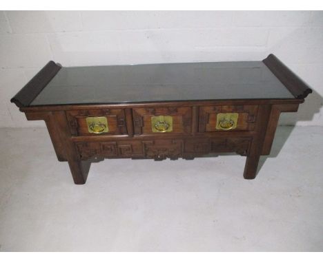 A Chinese hardwood low altar table with scroll end top, three drawers and brass handles - W 135cm D 50cm H 52cm
