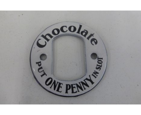 A "Chocolate Put One Penny in Slot" circular enamel vending machine escutcheon in excellent condition, 2 1/4" diameter.