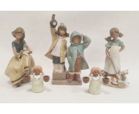 Lladro model of a seated girl with a cat on her lap, 21cm high, another Lladro model of two children with a lantern, another 