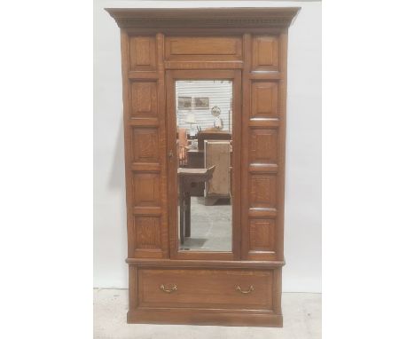 Early 20th century oak single door wardrobe, moulded cornice, panel decoration, mirror to door above single drawer, plinth ba