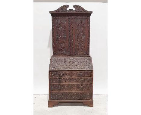 Carved oak bureau bookcase, swan-neck pediment above two carved doors enclosing shelves above the four two drawers, two cupbo