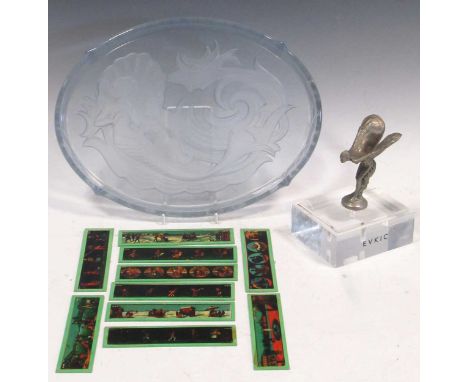 An opaque glass tray decorated with mermaids and a EVKIC winged car mascot; with a part set of magic lantern slides in boxPro