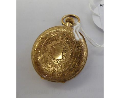 A gold coloured metal cased fob watch with engraved ornament, the keyless movement faced by an engine turned and floral ornam