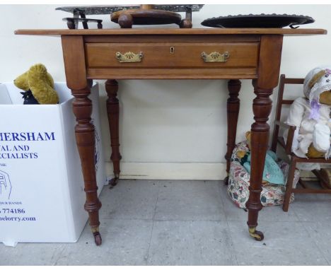 A late Victorian mahogany writing table, having an inset tooled hide scriber and overhanging top, the shallow frieze drawer w