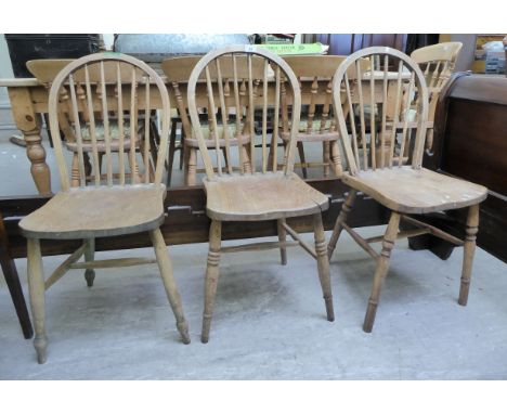 A set of three early 20thC bleached beech and elm framed Windsor hoop and stick back chairs, the solid seats raised on ellipt