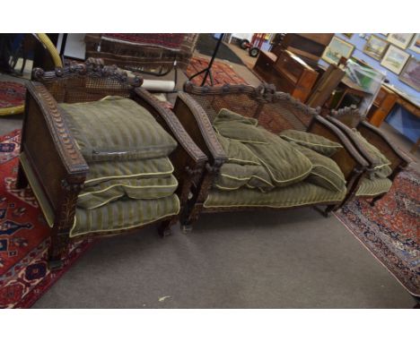 Victorian oak Bergere suite in the Gothic manner^ comprising a two-seater sofa and two matching easy chairs with double cane 