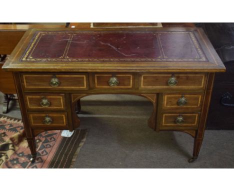 Edwardian inlaid mahogany desk^ gilt tooled red leather inset over seven drawers with short tapering square supports and bras