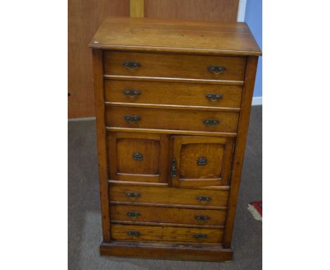 Late 19th century Wellington style light oak chest^ fitted with six graduated drawers and central cupboard with locking side 