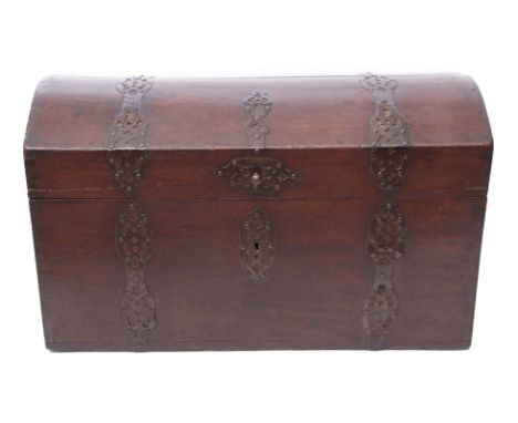 Heavy oak trunk or coffer with domed top and pierced metal strapwork mounts^ applied at either end with heavy cast iron swing
