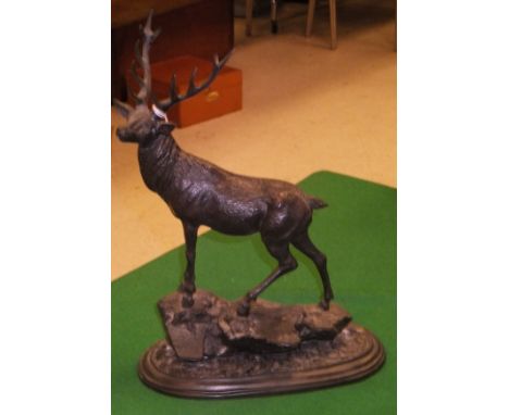 A modern bronze figure of a twelve point stag standing on a rock, raised on a plinth base