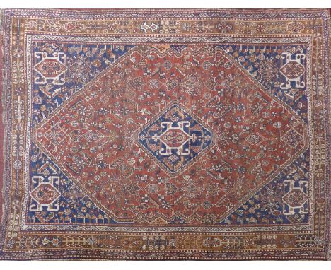 An antique Persian carpet with repeating geometric motifs within double diamond pendant, contained by geometric borders, 245 