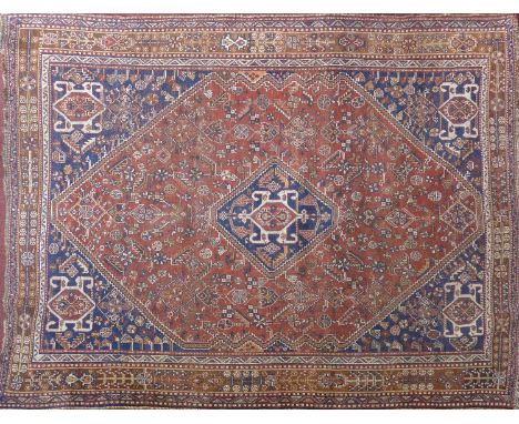 An antique Persian carpet with repeating geometric motifs within double diamond pendant, contained by geometric borders, 245 