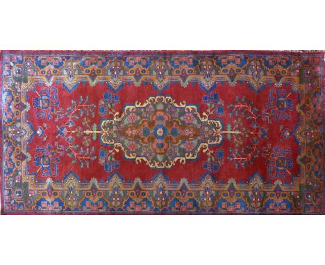 A Central Persian Bakhtiari carpet, central double pendent medallion with repeating petal motifs on a rouge field, within sty