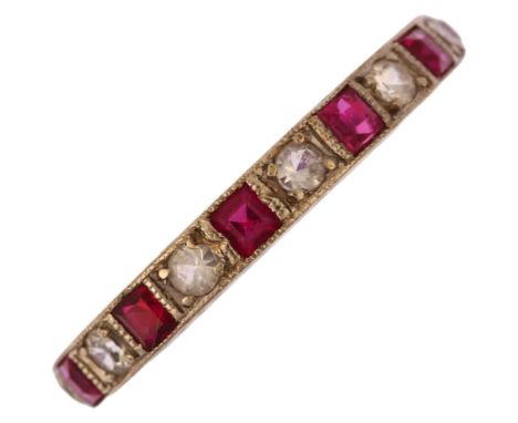 An Art Deco 9ct white gold ruby and paste full eternity ring, set with calibre-cut rubies and round-cut paste with engraved b