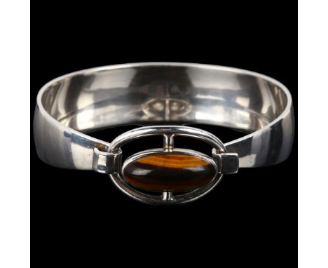 NIELS ERIK FROM - a Danish modernist sterling silver and tigers eye openwork torque bangle, set with oval cabochon tigers eye