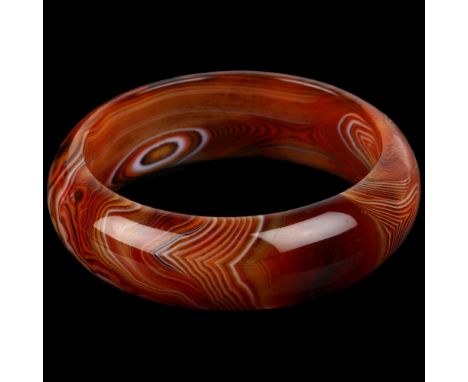 A modern polished Madagascan agate slave bangle, band width 20.7mm, internal circumference 18cm, 72.9gNo damage or repair 
