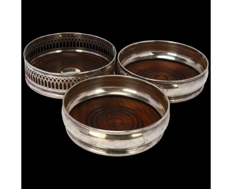A pair of Elizabeth II silver-mounted oak wine bottle coasters, London 1968, and another pierced silver example, Birmingham 1