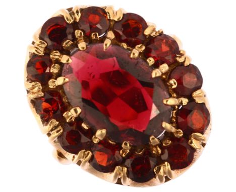 A large late 20th century garnet oval cluster ring, unmarked 9ct gold prong set with oval and round-cut garnets, setting heig